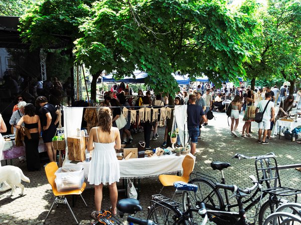 Menschen schauen sich auf einem Flohmarkt Waren an