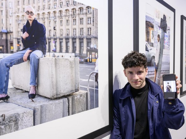 Sebastian Wells und Vsevolod Kazarin (auf dem Smartphone), Preisträger des Deutschen Friedenspreis für Fotografie 2023), vor ihrer Arbeit „Young People Photographed in Kyiv, April and May 2022“ 